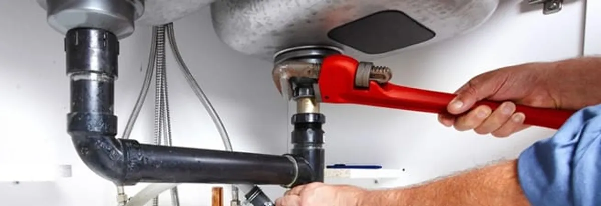 Garbage disposal repair technician tightening the sink drain and disposal connection in Yonkers, NY