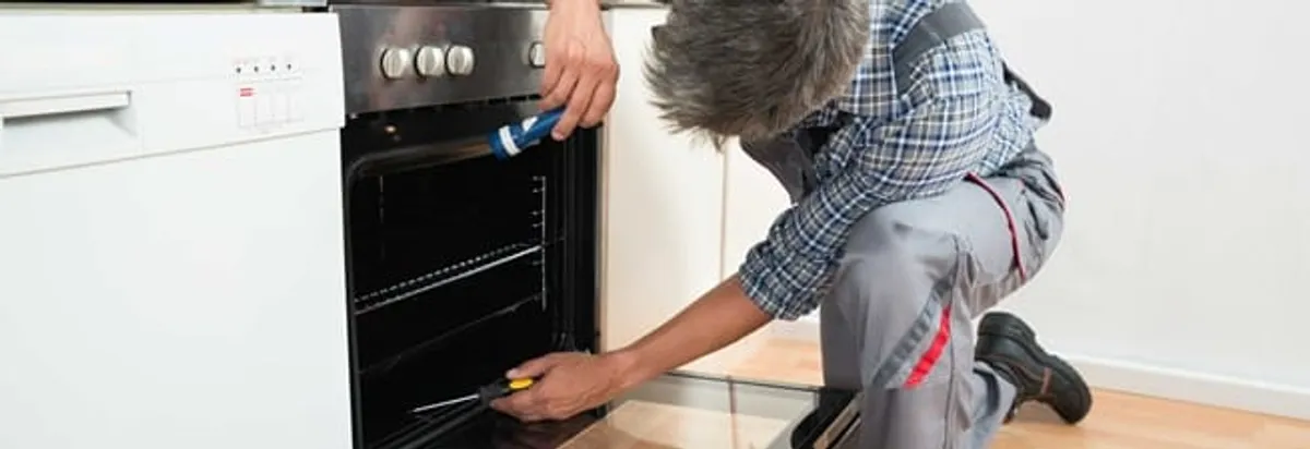 Oven repair technician inspecting and servicing an electric oven in Yonkers, NY